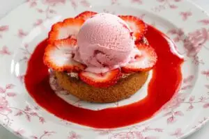 Top view of Basque cake topped with strawberry ice cream and surrounded by strawberry sauce.