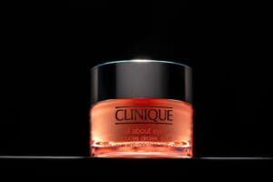 Clinique Eye Cream – Skincare Photography Cosmetic jar glowing under moody lighting, creating a luxurious feel with reflections enhancing its sleek design.